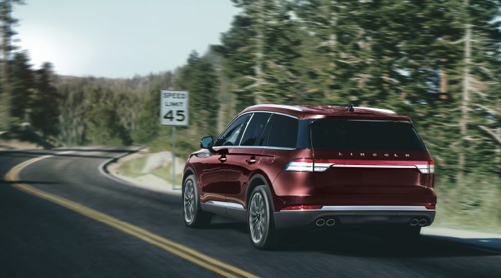 A 2024 Lincoln Aviator® SUV is being driven on a winding mountain road | Gray-Daniels Lincoln in Brandon MS