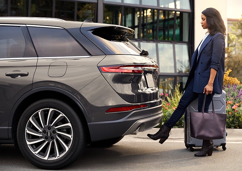 A woman with her hands full uses her foot to activate the available hands-free liftgate. | Gray-Daniels Lincoln in Brandon MS
