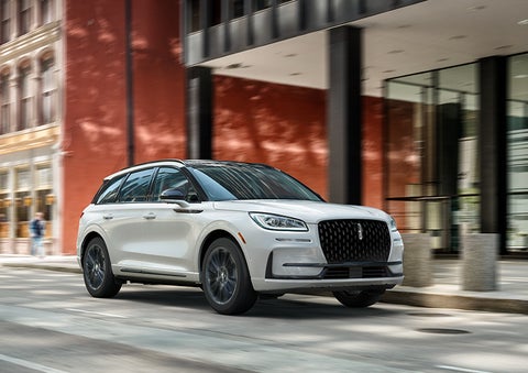 The 2024 Lincoln Corsair® SUV with the Jet Appearance Package and a Pristine White exterior is parked on a city street. | Gray-Daniels Lincoln in Brandon MS