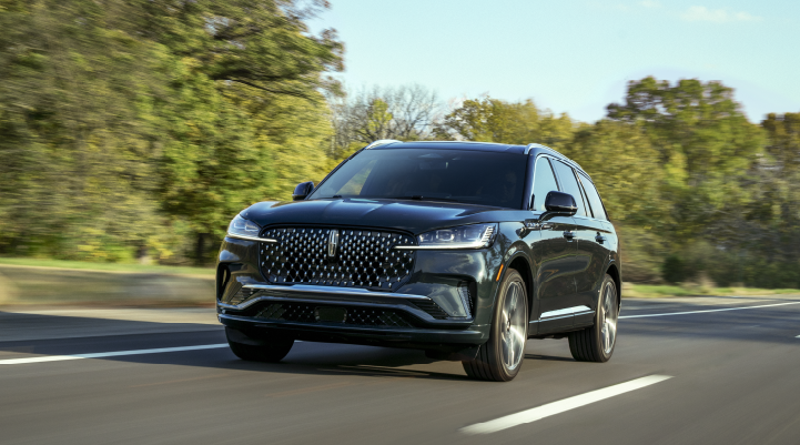 A 2025 Lincoln Black Label Aviator® SUV is being driven down a road lined with trees. | Gray-Daniels Lincoln in Brandon MS