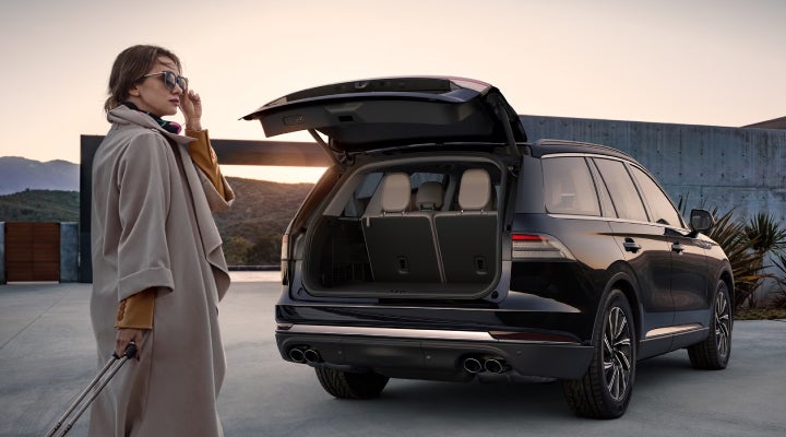 A woman approaches a 2026 Lincoln Aviator® SUV with its rear liftgate open. | Gray-Daniels Lincoln in Brandon MS